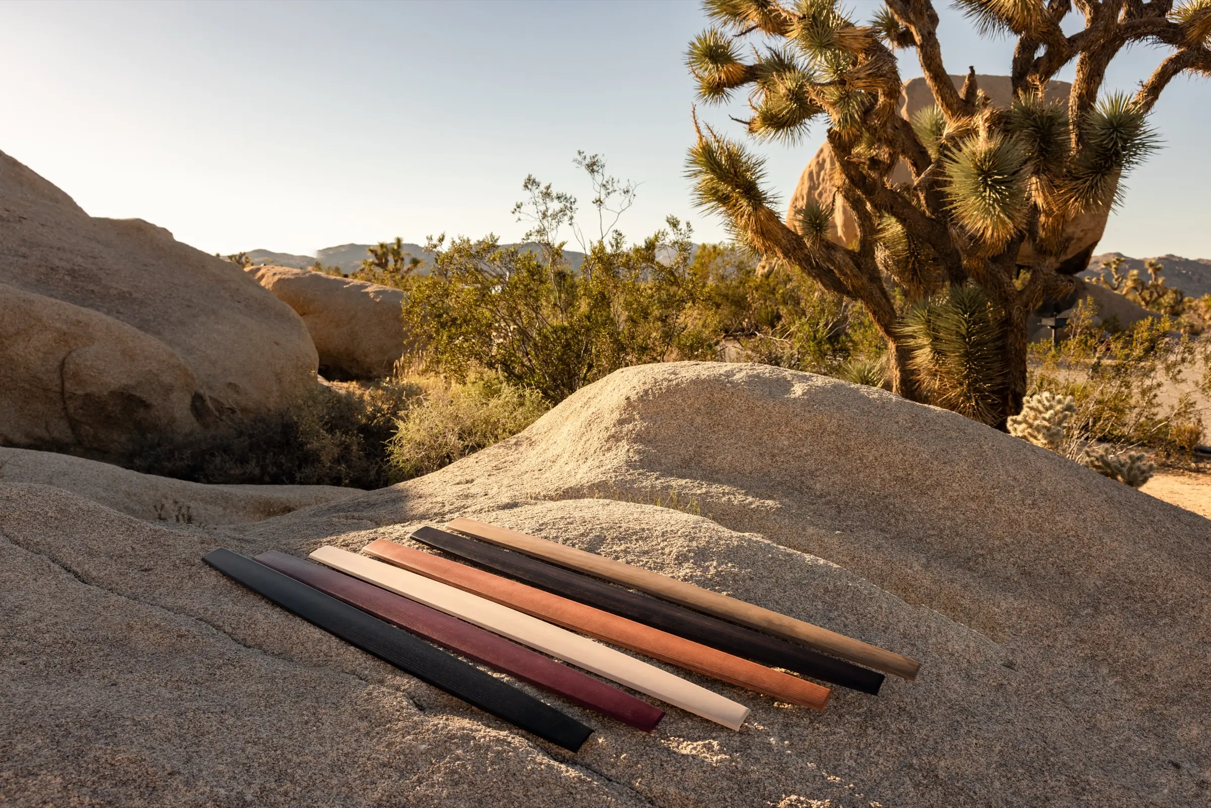Hills wood panels in walnut, ebony, maple and purple heart, laid on a rock in the California desert